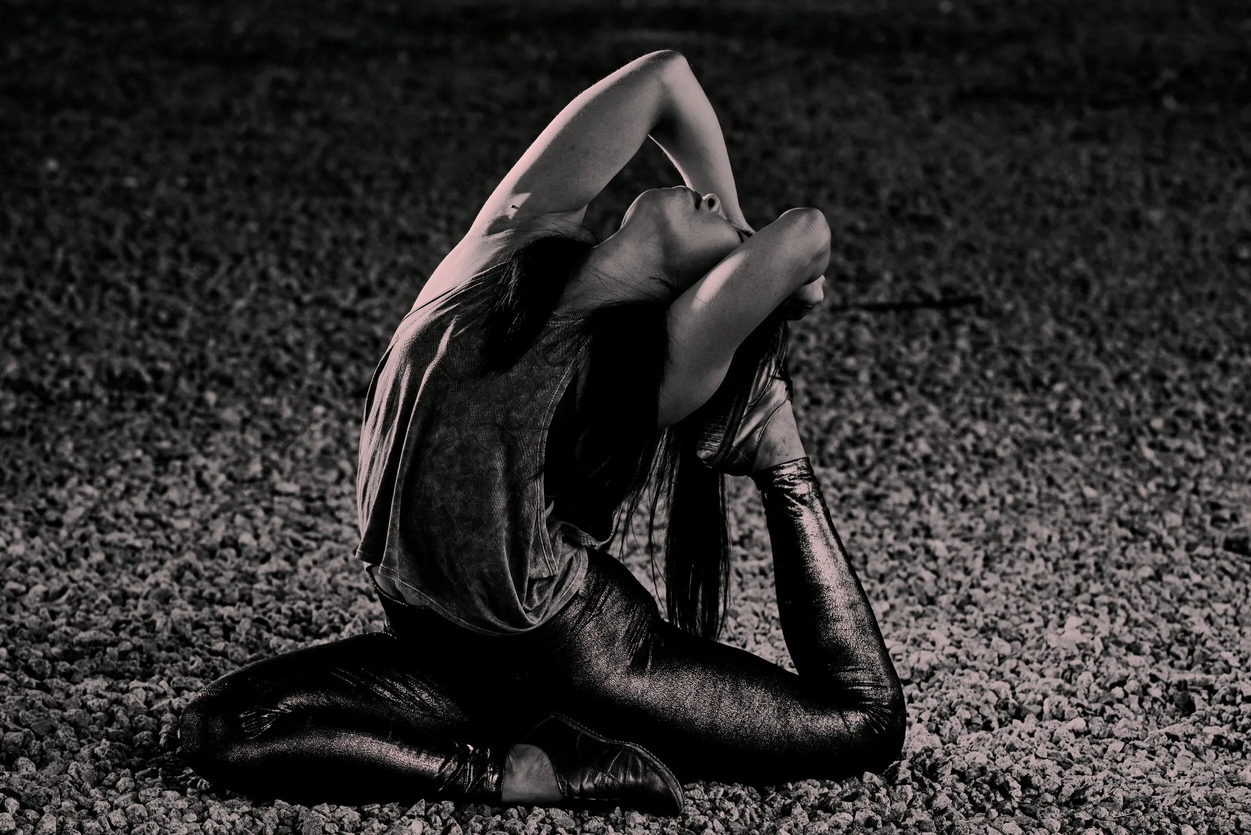 Dancer in a deep backbend, photographed on gravel at night